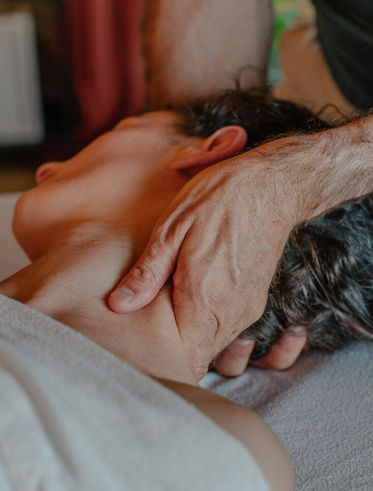 Les mains du masseur qui massent le cou d'une cliente pour soulager les tensions